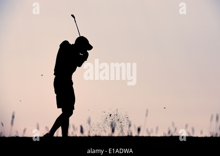 Silhouette di un giocatore di golf in un colpo al tramonto Foto Stock