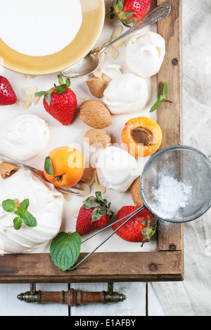 Meringa fatti in casa con Albicocche Fragole, mandorle e crema. Ingredienti per il dessert Eton mess. Vista dall'alto. Foto Stock