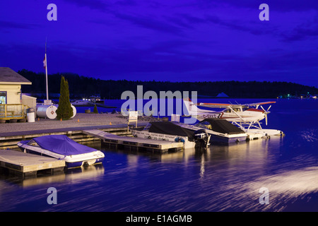 Un idrovolanti e barche a motore legato alla riva al tramonto davanti a 'Georgian Bay Airways'. Parry Sound Harbour, Ontario, Canada. Foto Stock