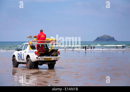 Polzeath, Cornwall Regno Unito. Il 28 maggio 2014. Un bagnino dal Royal National scialuppa di salvataggio istituzione (RNLI) continua a guardare oltre i surfisti e bagnanti a Polzeath Beach in Cornwall Inghilterra. La zona era occupato con le famiglie di prendere una scuola a metà termine rottura nel clima mite. Foto: Richard Wayman/Alamy Live News Foto Stock