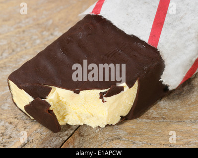 Cioccolato fondente rivestito bar gelateria in un involucro di carta Foto Stock