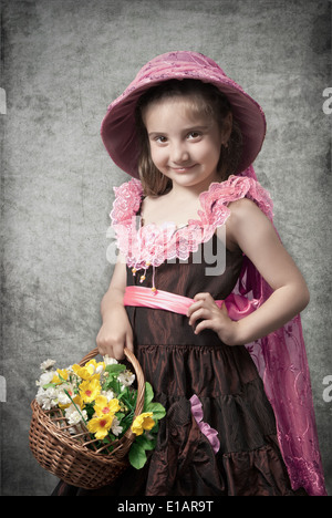 La foto in stile retrò, la bambina con un cesto di fiori Foto Stock