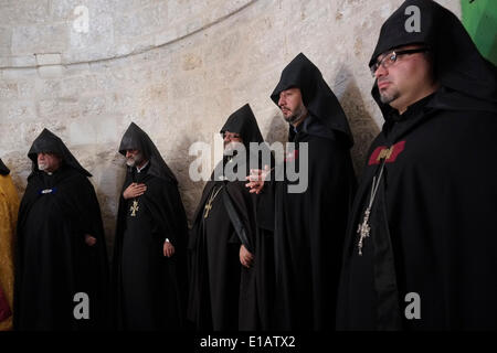 I membri della chiesa Apostolica Armena con cope con cappuccio nero prendono parte ad una cerimonia nella Cappella dell'Ascensione sul Monte degli Ulivi, il luogo in cui i fedeli tradizionalmente credono di essere il luogo terreno in cui Gesù ascese al Cielo dopo la sua risurrezione. Gerusalemme Est 29 maggio 2014. Ogni anno, giovedì 40° giorno dal giorno di Pasqua, i cristiani di tutto il mondo celebrano l'Ascensione corporea di Gesù al Cielo. Foto Stock