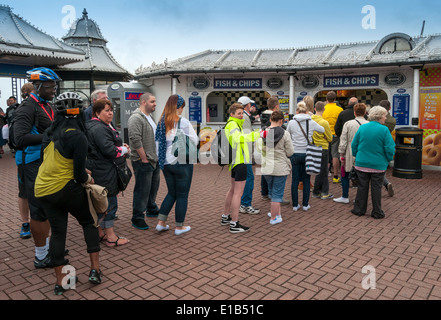 La gente in coda fino a comprare Take-away Pesce e Patatine sul molo di Brighton, Inghilterra, Regno Unito Foto Stock