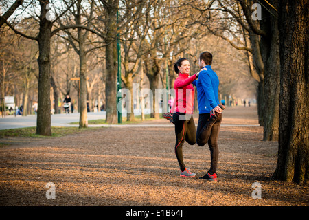 Coppia giovane lo stiramento dei muscoli prima di jogging - outdoor in natura Foto Stock