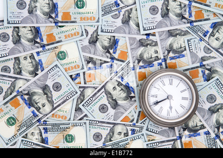 Concettuale background finanziario di American 100 fatture del dollaro con Benjamin Franklinf rivolta verso l'alto e un orologio vintage depictin Foto Stock