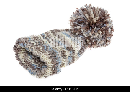 Lanuginoso caldo Cappello invernale con un enorme pompom mano a maglia da chiazze di lana di colore grigio su sfondo bianco Foto Stock