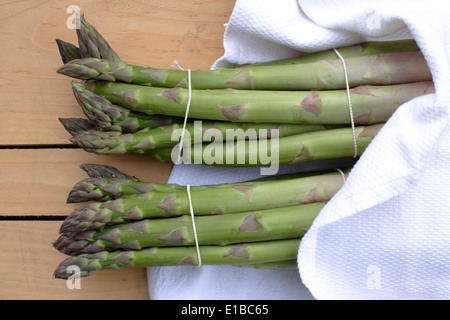 Asparago Verde giacente su di un tavolo di legno Foto Stock