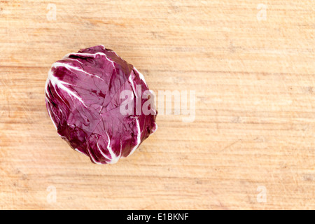 Vista aerea di un singolo radicchio rosso ricco di antocianina su un bambù tagliere con copyspace Foto Stock