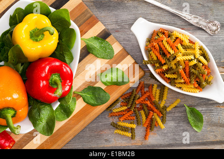 Ingredienti per una deliziosa fusilli con una vista aerea di freschi dolci colorati i peperoni in rosso giallo e arancione Foto Stock