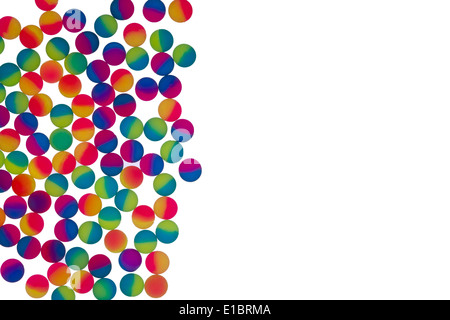Confine di illuminato brillantemente colorato bicolor sfere di plastica disposti come singolo strato a sinistra del telaio isolato su bianco Foto Stock