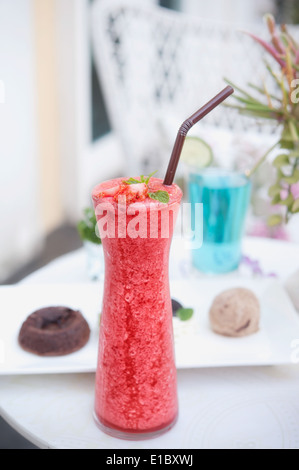 Frullato di fragole in vetro sul tavolo Foto Stock