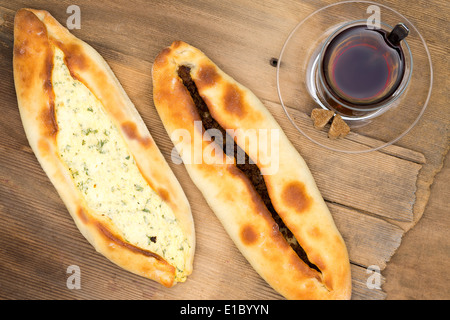 Vioew dal di sopra di due crusty pides turco, un cotto focacce azzime, wth di formaggio e di carne di manzo e di vetro caldo di tè, overhead v Foto Stock