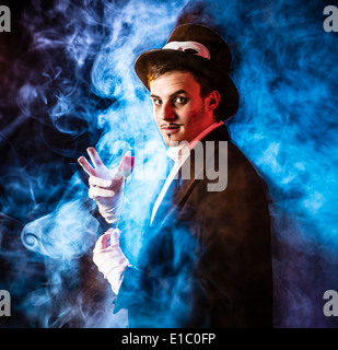 Un mago malvagio inghirlandato in fumo tenendo una rosa rossa Foto Stock