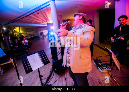 Un uomo che ha partecipato al "Bandaoke' - live band karaoke a Aberystwyth Arts Center, Wales UK Foto Stock