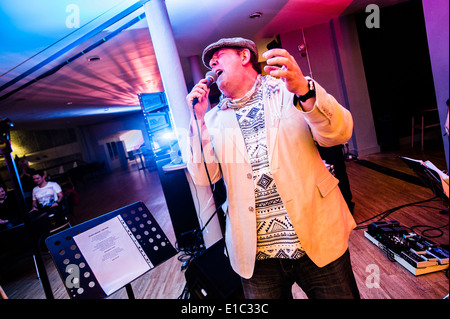 Un uomo che ha partecipato al "Bandaoke' - live band karaoke a Aberystwyth Arts Center, Wales UK Foto Stock