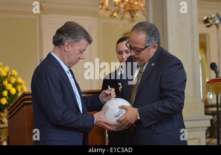 Bogotà, Colombia. 29 Maggio, 2014. Immagine fornita da Colombia assumerà la Presidenza mostra il presidente colombiano Juan Manuel Santos (L) firma la sfera simbolica della campagna mondiale contro l HIV, "Tutelare l' obiettivo del programma congiunto delle Nazioni Unite per l'HIV e l'AIDS (UNAIDS), in Nariño's House, a Bogotà, Colombia, il 29 maggio 2014. Secondo la stampa locale, ogni cheif di stato e il capitano delle squadre nazionali che frequentano la FIFA World Cup 2014, partecipare alla campagna, che sarà lanciato ufficialmente il 9 giugno. Credito: Juan Pablo Bello/Colombia la Presidenza/Xinhua/Alamy Live News Foto Stock