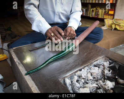 India Rajasthan, Jodhpur, artigiano rendendo lac verde bangle, laminazione del lac riscaldata oltre il fuoco di carbone Foto Stock