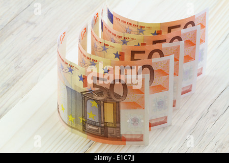 Le banconote in euro in una riga su una superficie di legno Foto Stock