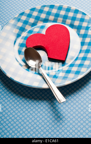 Cuore di san valentino forma parzialmente consumato su un piatto e fame per il concetto di amore Foto Stock