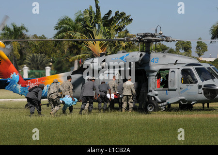 Stati Uniti I soldati dell esercito e haitiane i membri del servizio medico del carico di pazienti a bordo di una flotta MH-60S Knighthawk elicottero Gen 21, 2010, Foto Stock