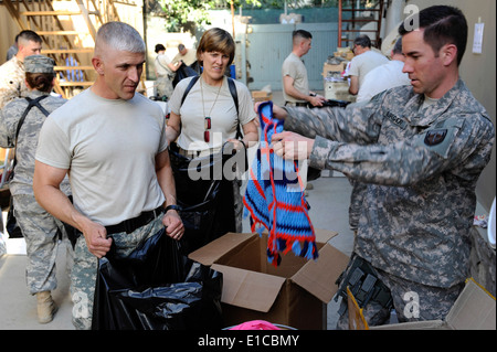 Da sinistra, U.S. Navy Senior Chief Michael Jaeger e esercito Col. LeAnn Burch stand in linea per ricevere abbigliamento dalla Air Force Maj Foto Stock