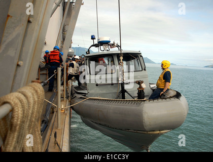 Stati Uniti I marinai a bordo del dock anfibio sbarco nave USS Oak Hill (LSD 51) preparare per abbassare una rigida-scafo gommone in t Foto Stock