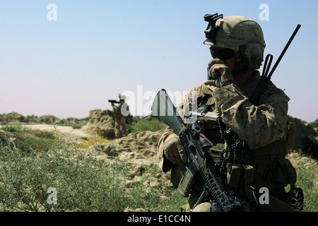 Stati Uniti Marine Corps Lance Cpl. Scott Nechay utilizza una radio durante una pattuglia di sicurezza nella provincia di Helmand in Afghanistan luglio 27, Foto Stock