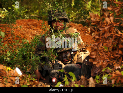 Stati Uniti Navy Seabees dalla base navale di Mobile Battaglione di costruzione 133 eseguire la scansione della zona dalla loro posizione di combattimento durante un campo traini Foto Stock