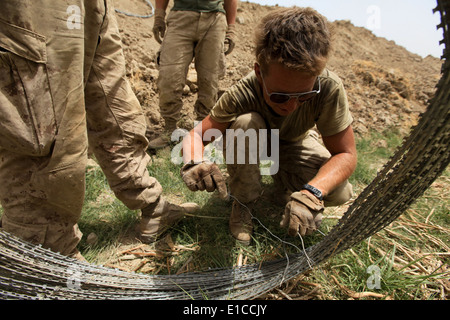 Stati Uniti Marine Corps Sgt. Beau Varner, un ingegnere consulente con società alfa, 1° Battaglione, quinto reggimento Marine, si snoda un bundle Foto Stock