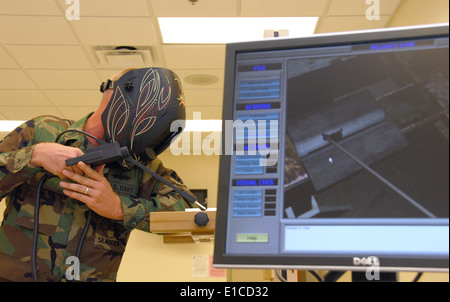 Stati Uniti Navy lavoratore in acciaio di prima classe Josh Eichelberger dimostra una saldatrice virtuale sistema alla costruzione navale Battaglione Cen Foto Stock