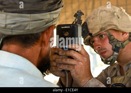 Stati Uniti Marine Corps Lance Cpl. Brock Wilki, con 1° Battaglione, quinto reggimento Marine, scansiona l'iride di un uomo afghano a afghane uno Foto Stock