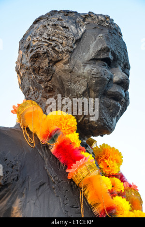 Fiori sotto la statua di Nelson Mandela il giorno egli defunto Foto Stock