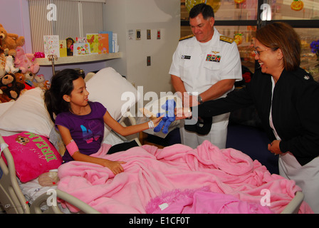Stati Uniti Navy Cmdr. Melanie O'Brien, a destra, il comandante della Marina Militare del distretto di reclutamento Houston, dà un orso farcito con un p Foto Stock