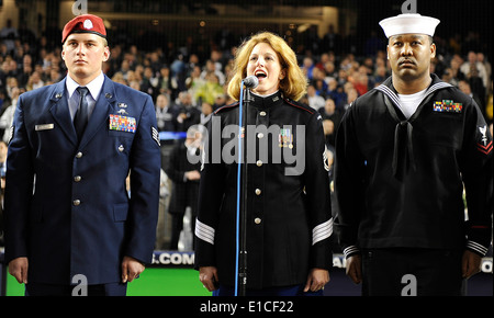 Stati Uniti Army Sgt. Mary Kay Messenger, centro, canta Dio benedica l America come Air Force combat controller Sgt personale. Jesse Schrader, le Foto Stock