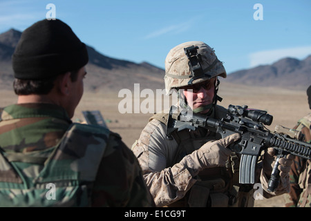Stati Uniti Marine Corps 1Lt. Christopher Doty allenatori di un esercito nazionale afghano soldato con la quarta società, avanti battaglione di supporto Foto Stock