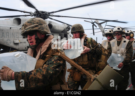 Stati Uniti Marines assegnato alla ventiduesima Marine Expeditionary Unit load acqua imbottigliata su un CH-53E Super Stallion elicottero a bordo t Foto Stock