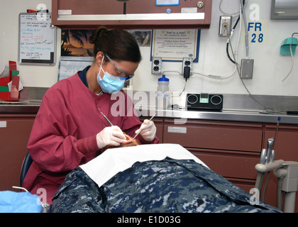 Stati Uniti Navy Corpsman ospedale di terza classe Emily Brown esegue una routine di pulizia dentale su un marinaio a bordo della portaerei US Foto Stock
