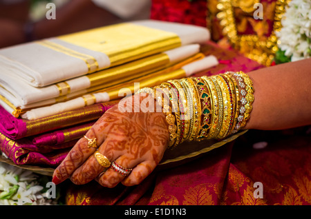 Le mani di un indiano sposa adornata con gioielli, schiave e verniciati con colore henné Foto Stock