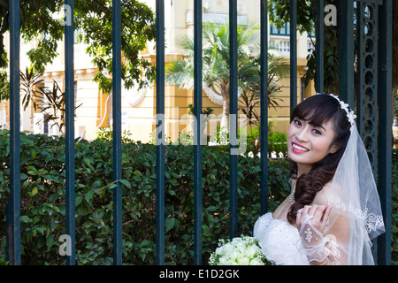 Una ragazza vietnamita in abito nuziale pone per le fotografie. Il Vietnam custom vede questo rituale fatto mesi prima delle nozze reali. Foto Stock