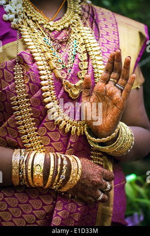 Le mani di un indiano sposa adornata con gioielli, schiave e verniciati con colore henné Foto Stock