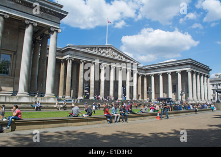 La gente seduta fuori l'ingresso al British Museum di Londra, Inghilterra Foto Stock