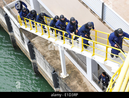 Stati Uniti Costa guardie attaccato al USCGC Mellon (WHEC 717) sposta su una scala prima di cancellare uno spazio durante la simulazione di una boardi Foto Stock