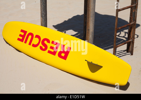 Piccolo giallo la barca di salvataggio giace sulla spiaggia Foto Stock