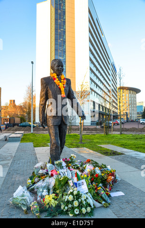 Fiori sotto la statua di Nelson Mandela il giorno egli defunto Foto Stock