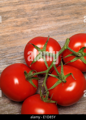 Cluster maturi pomodori sul legno rustico sfondo Foto Stock
