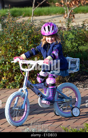 Quattro 4 anno vecchia ragazza cavalcare la sua bici Foto Stock