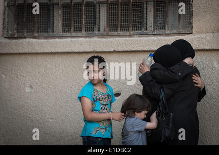 Damasco, Siria. 31 Maggio, 2014. Siro le donne e i bambini abbraccio con ogni altro a Zahi Alsameen sevring scuola come un campo profughi per gli studenti e per le donne in Jaramana distretto, a sud-est di Damasco Capitale della Siria, il 31 maggio 2014, prima delle elezioni presidenziali del 3 giugno. Credito: Pan Chaoyue/Xinhua/Alamy Live News Foto Stock