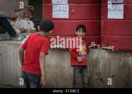 Damasco, Siria. 31 Maggio, 2014. Due ragazzi Siriani sono circa di bere acqua a Zahi Alsameen sevring scuola come un campo profughi per gli studenti e per le donne in Jaramana distretto, a sud-est di Damasco Capitale della Siria, il 31 maggio 2014, prima delle elezioni presidenziali del 3 giugno. Credito: Pan Chaoyue/Xinhua/Alamy Live News Foto Stock