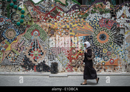 Damasco, Siria. 31 Maggio, 2014. Una donna siriana passeggiate da una parete realizzata con materiali sprecato in Damasco Capitale della Siria, il 31 maggio 2014, in vista delle prossime elezioni presidenziali del 3 giugno. Credito: Pan Chaoyue/Xinhua/Alamy Live News Foto Stock